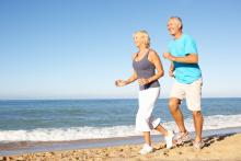 Senior couple running on the beach